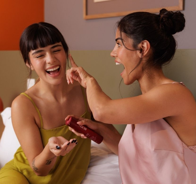 Two women applying bejou products